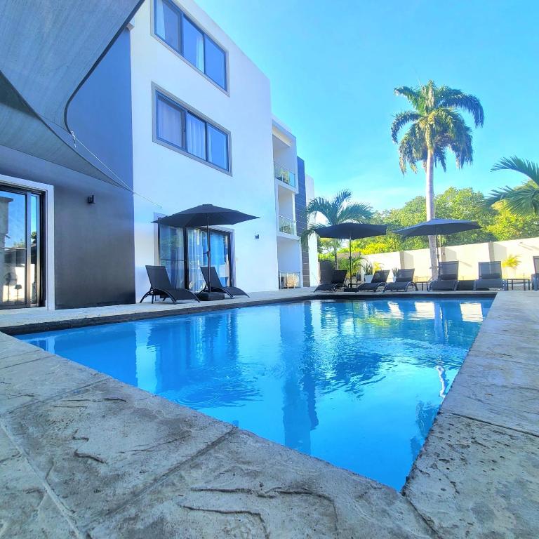a swimming pool in front of a building at LEVEL suites in Sosúa