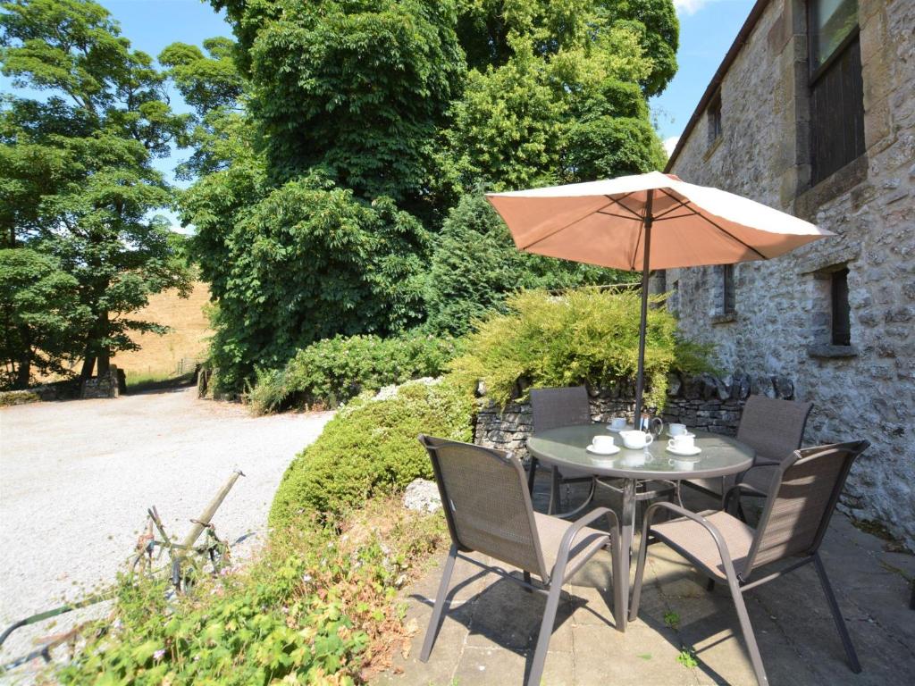ハーティントンにある2 Bed in Hartington 62803のパティオに置かれたテーブルと椅子、そして傘