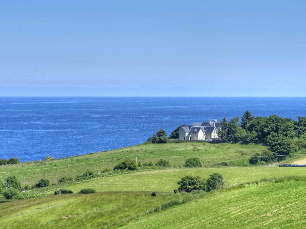 a house on a hill next to the ocean at 4 Bed in Coldingham CA256 in Coldingham