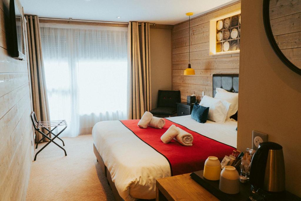 Una habitación de hotel con una cama con toallas. en Hotel Edelweiss, en Courchevel