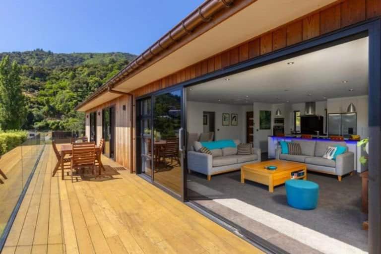 a house with a wooden deck with a living room at Great getaway in Picton