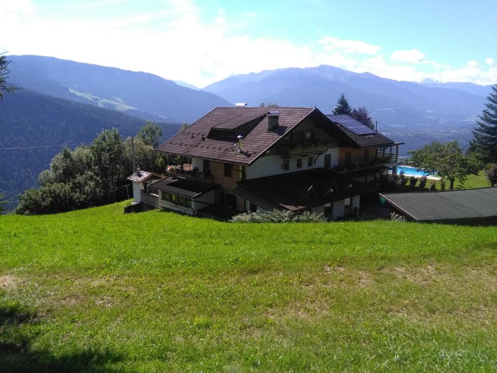 una casa sentada en la cima de una colina verde en Pension Marianne, en Maranza