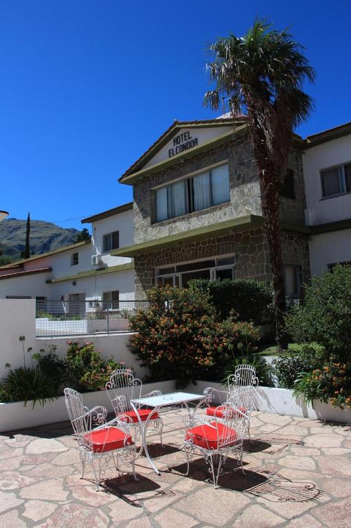 a table and chairs in front of a building at El Condor Hotel SPA in Merlo