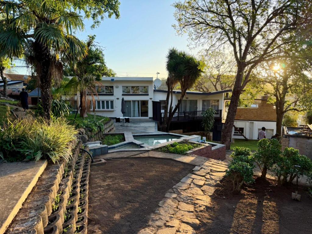 una casa con piscina e palme di On The Moon Hospitality and Conference Facility a East London