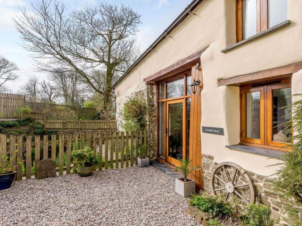 a cottage with a wooden door and a fence at 2 Bed in Bude 43239 in Pancrasweek