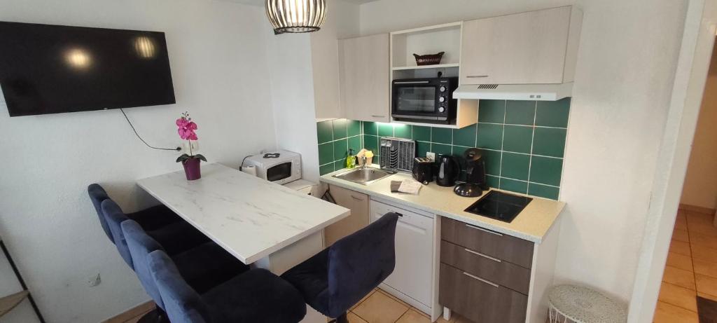 a kitchen with a table and chairs in a kitchen at Appartement face à la Gare in Annemasse