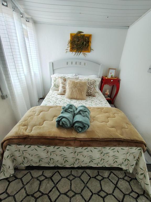 ein Schlafzimmer mit einem großen Bett mit Decken und Kissen in der Unterkunft Sítio das Águas in Santa Teresa