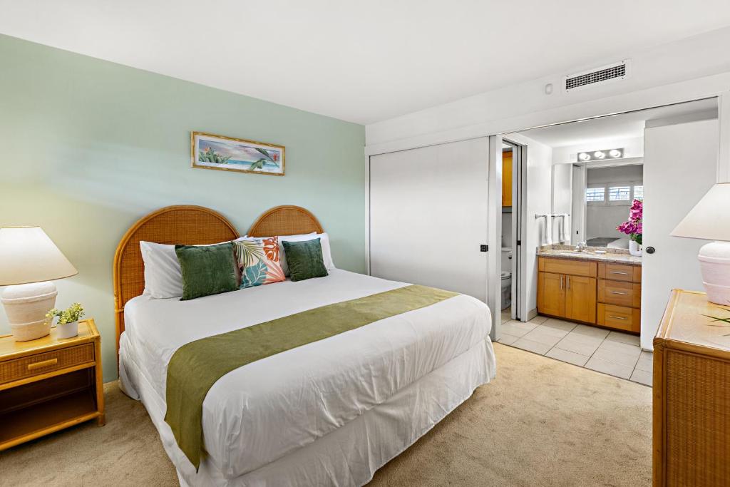 Un dormitorio con una cama grande y un baño. en Sugar Beach 304, en Kihei