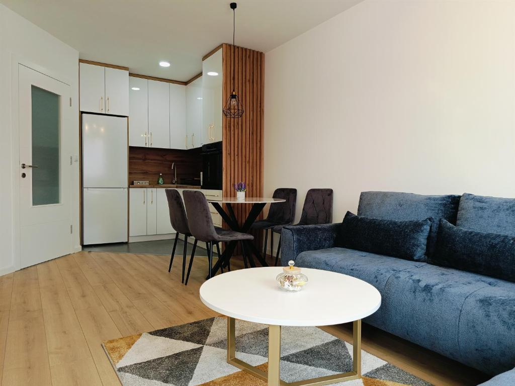 a living room with a blue couch and a table at Fort view in Doboj
