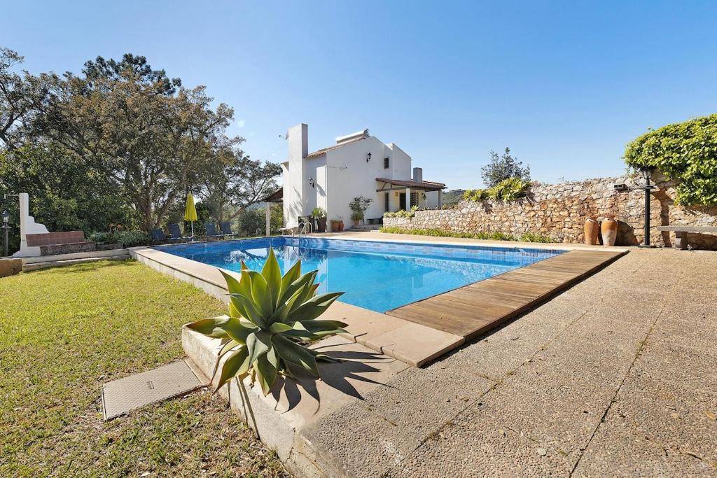 a swimming pool in front of a house at 30min from beach Seclueded House with pool Quinta La Rabide in Azeitao