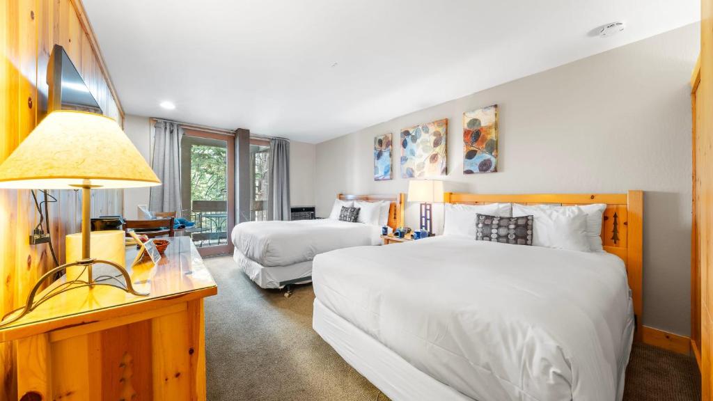 Truckee-Tahoe AirportCozy Northstar Village Escape w Forest Views Easy Lift Access Alpenglow Vista by AvantStay的一间卧室，配有两张床和一张带灯的书桌