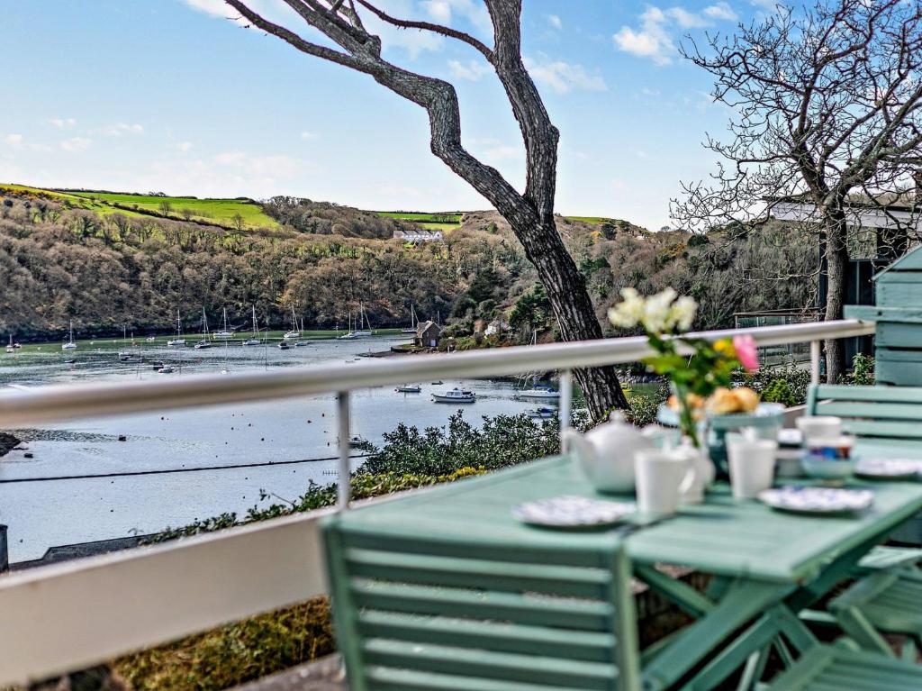 una mesa en un balcón con vistas al agua en 3 Bed in Newton Ferrers 90945, en Newton Ferrers