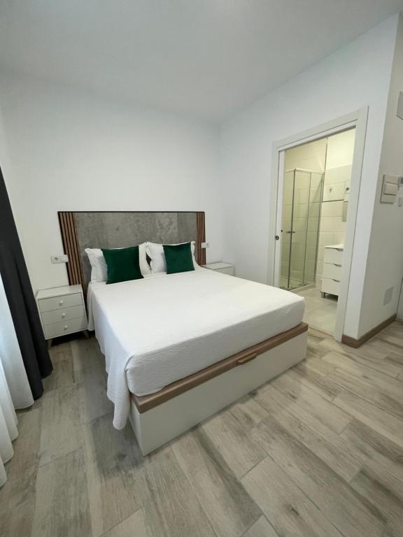 a bedroom with a large white bed and a mirror at Paseo Malecón Hab in Monforte de Lemos