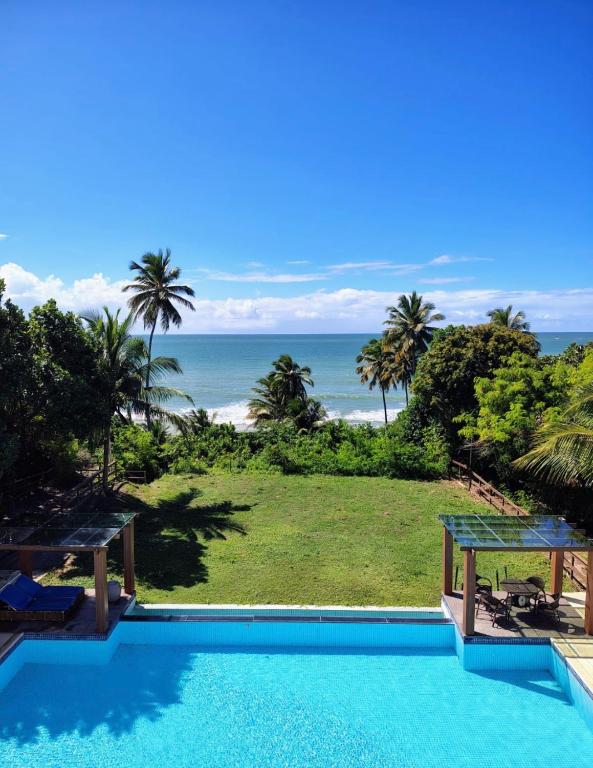 a swimming pool with a view of the ocean at Flat a Beira Mar em Carapibus PB in Conde
