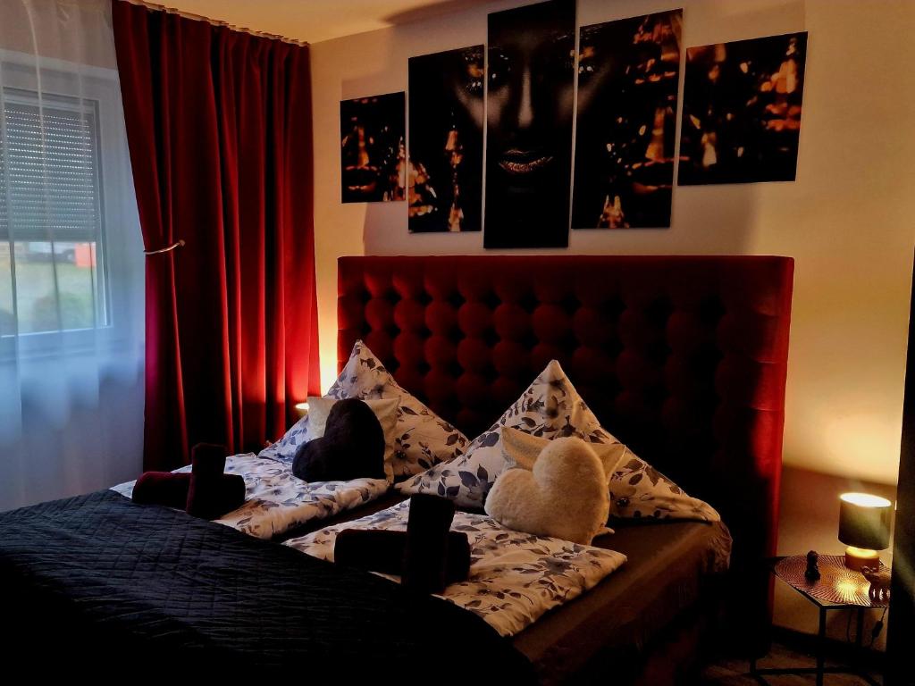 a bedroom with a bed with a red head board at Mefady Ferienhaus Stadtkyll in Stadtkyll
