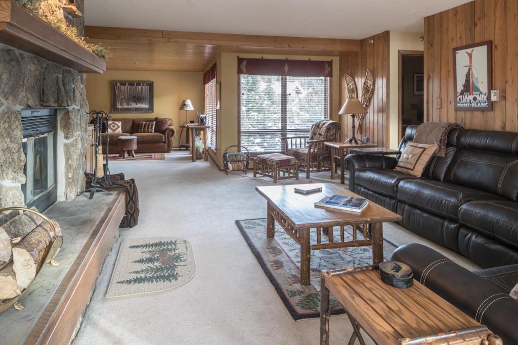 a living room with a leather couch and a fireplace at Skycrest 1714 in Big Sky