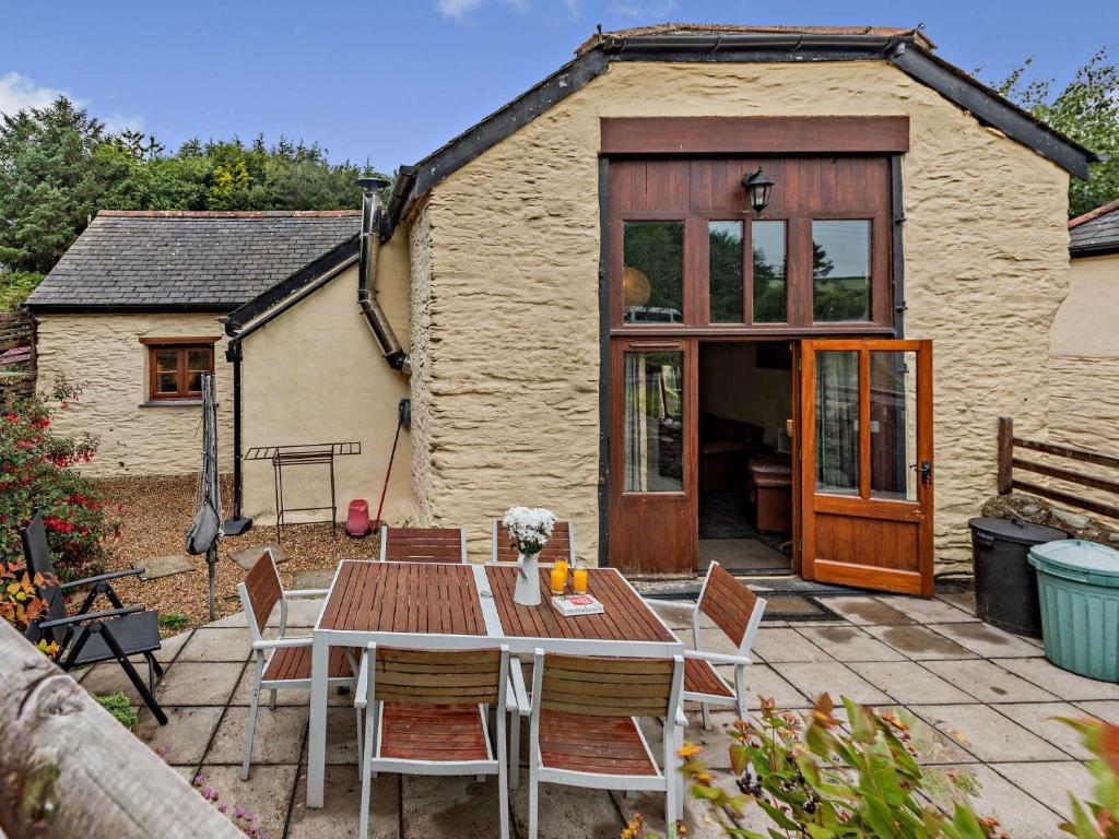 un patio con tavolo, sedie e una casa di 3 Bed in Ilfracombe GRAIC a West Down