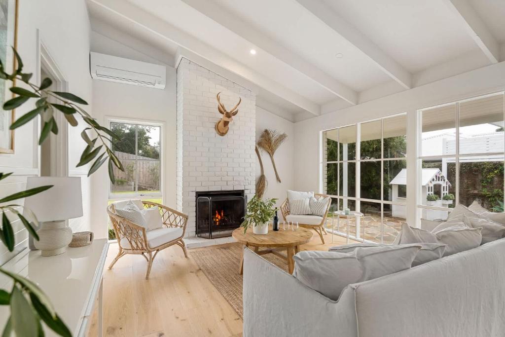 a living room with a couch and a fireplace at Backbeach House 1km to Beach in Blairgowrie