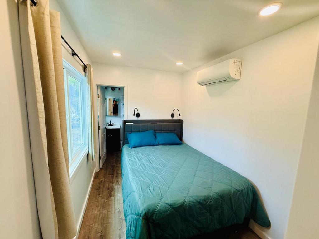 a bedroom with a green bed in a room at Hibiscus Hale - Perfect for 2! in Waialua