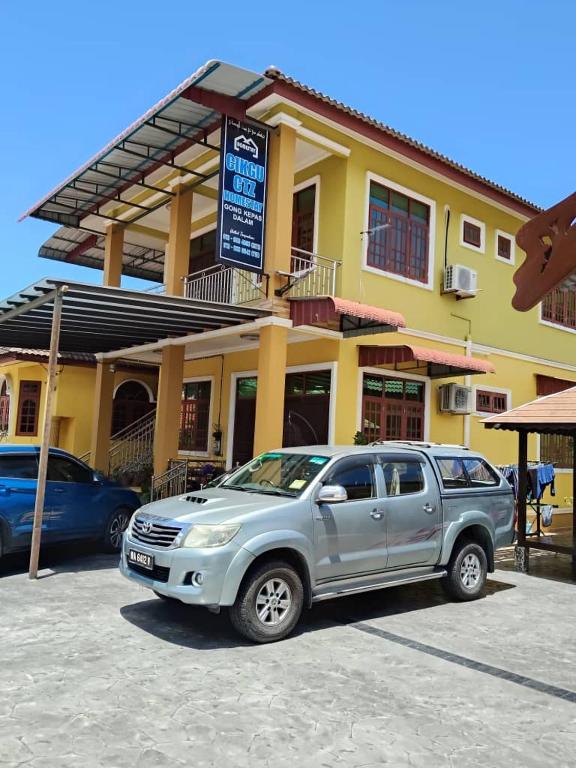 a silver suv parked in front of a building at Cikgu CTZ Homestay A in Kampung Raja