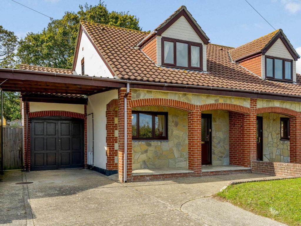una casa de ladrillo con un garaje negro en 2 bed in Totland Bay IC003, en Freshwater