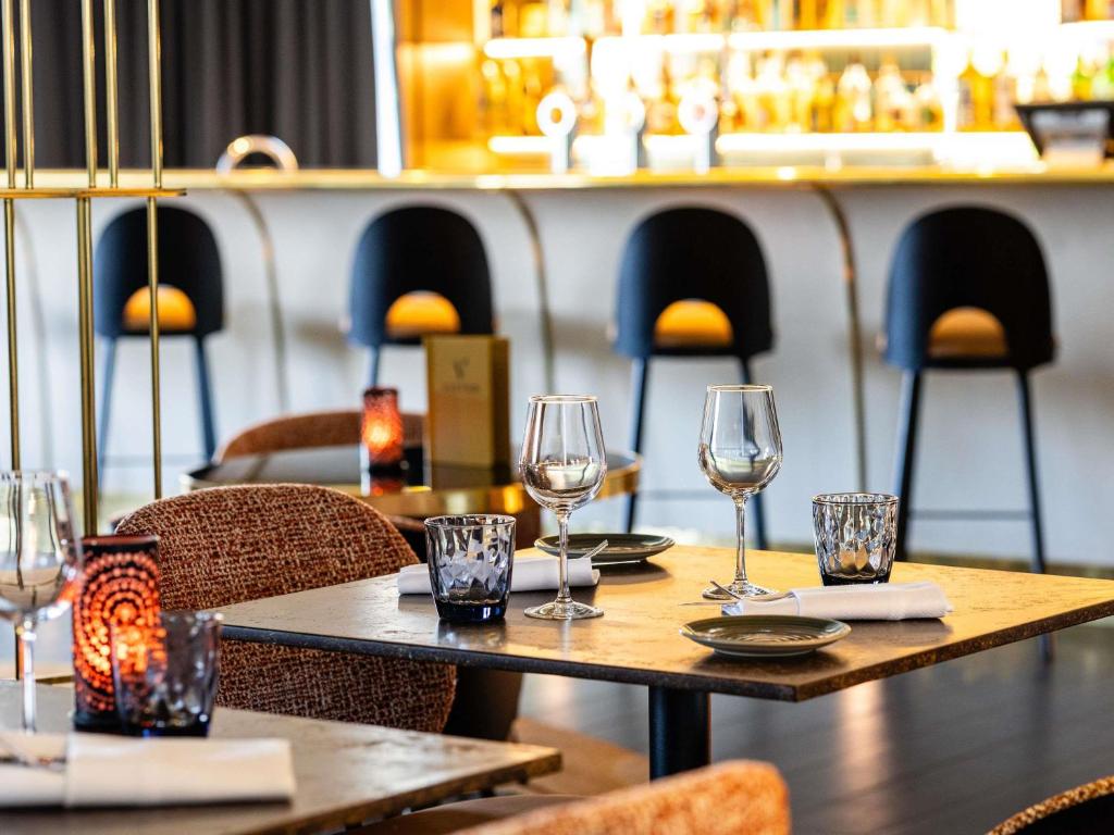 a table in a restaurant with wine glasses on it at Pullman Brussels Centre Midi in Brussels