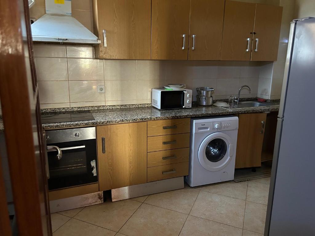 a kitchen with a washing machine and a microwave at 比绍民宿 in Bissau