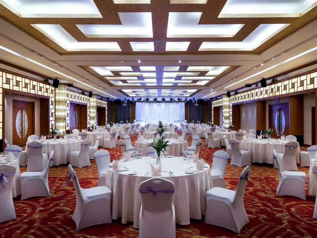 a banquet hall with white tables and white chairs at Pullman Zhangjiajie Hotel - Instagrammable in Zhangjiajie