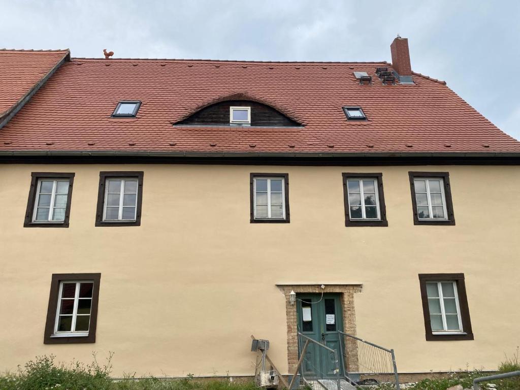 a large yellow house with a red roof at Hof Ohnesorge in Teutschenthal