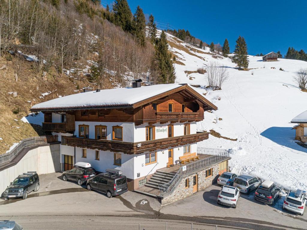 a large house with cars parked in a parking lot at Ferienhaus Almhof in Gerlosberg