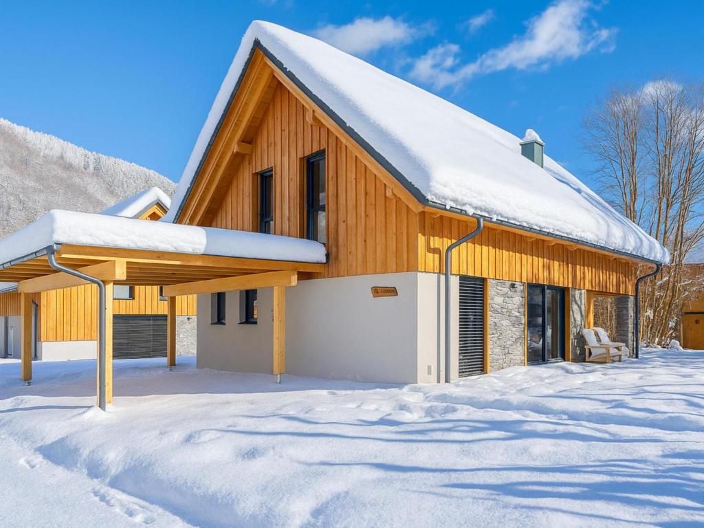 a wooden building with snow on the ground at Mountain Chalet Arnica in Sankt Lorenzen ob Murau