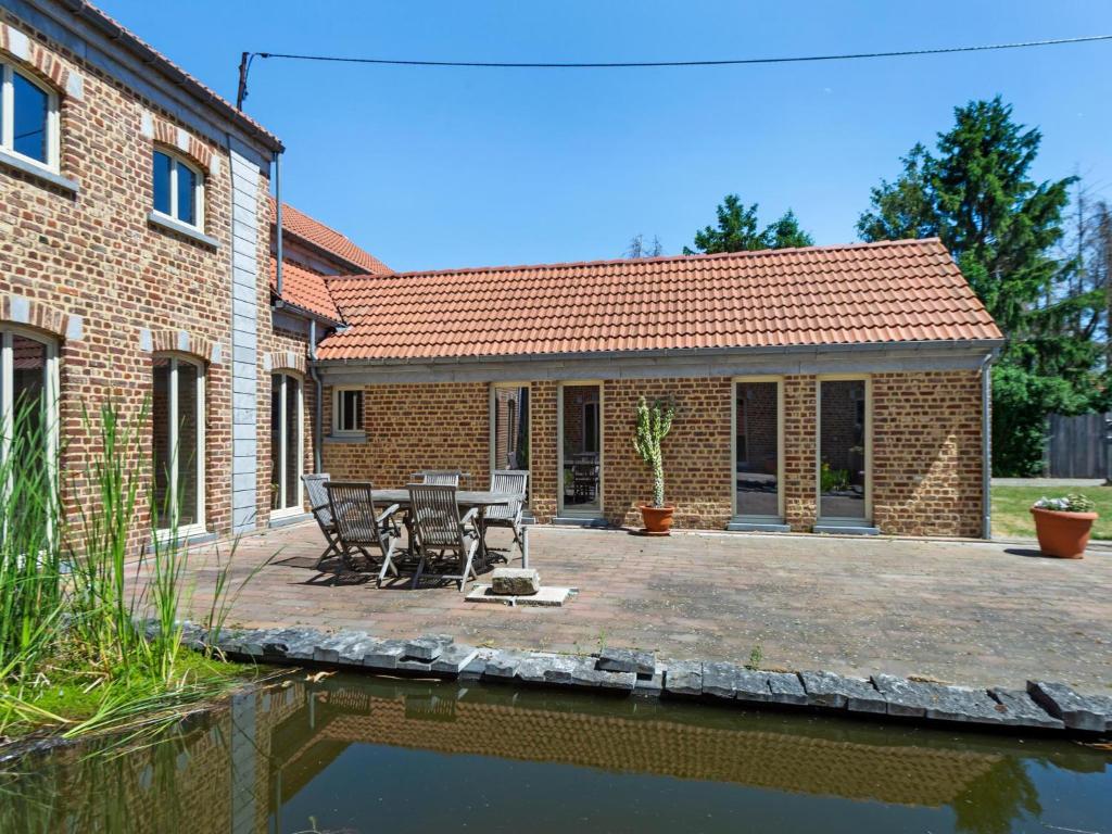 a patio with a table and chairs next to a house at Quanto B in Glabbeek