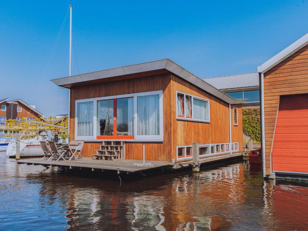 a house on a dock on a body of water at Woonark De Woude in Uitgeest