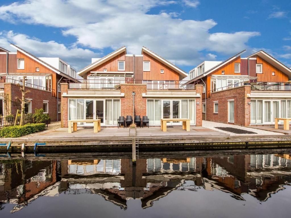 an apartment building with a reflection in the water at Assum Great in Uitgeest