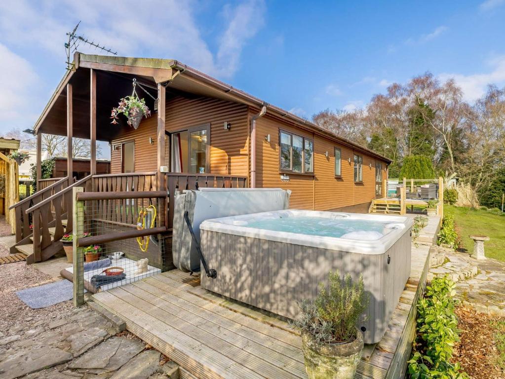 Whitegateにある1 Bed in Whitegate 91266のウッドデッキにホットタブが付いています。