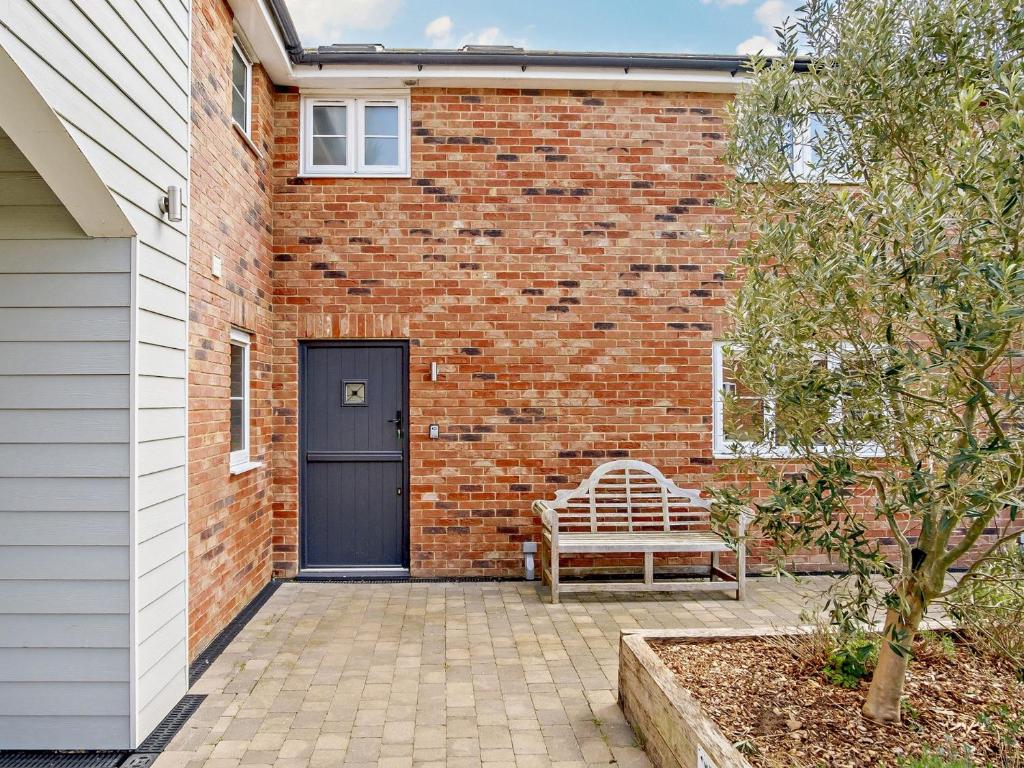 ニューポートにある4 Bed in Newport 90249のレンガ造りの建物の前に座るベンチ