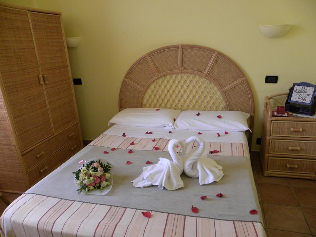 - une chambre avec un lit orné de roses dans l'établissement Soggiorno Marino San Giuseppe, à Imperia