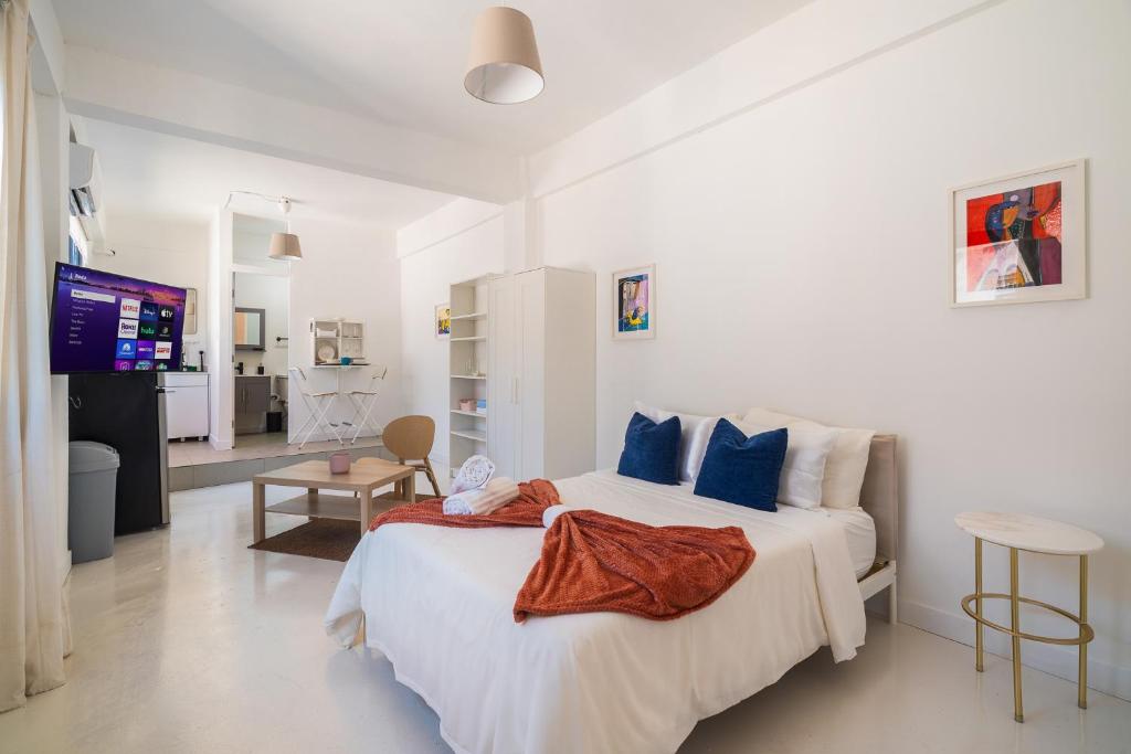 a white bedroom with a large bed and a television at Luma Boutique Collection by PH in San Juan