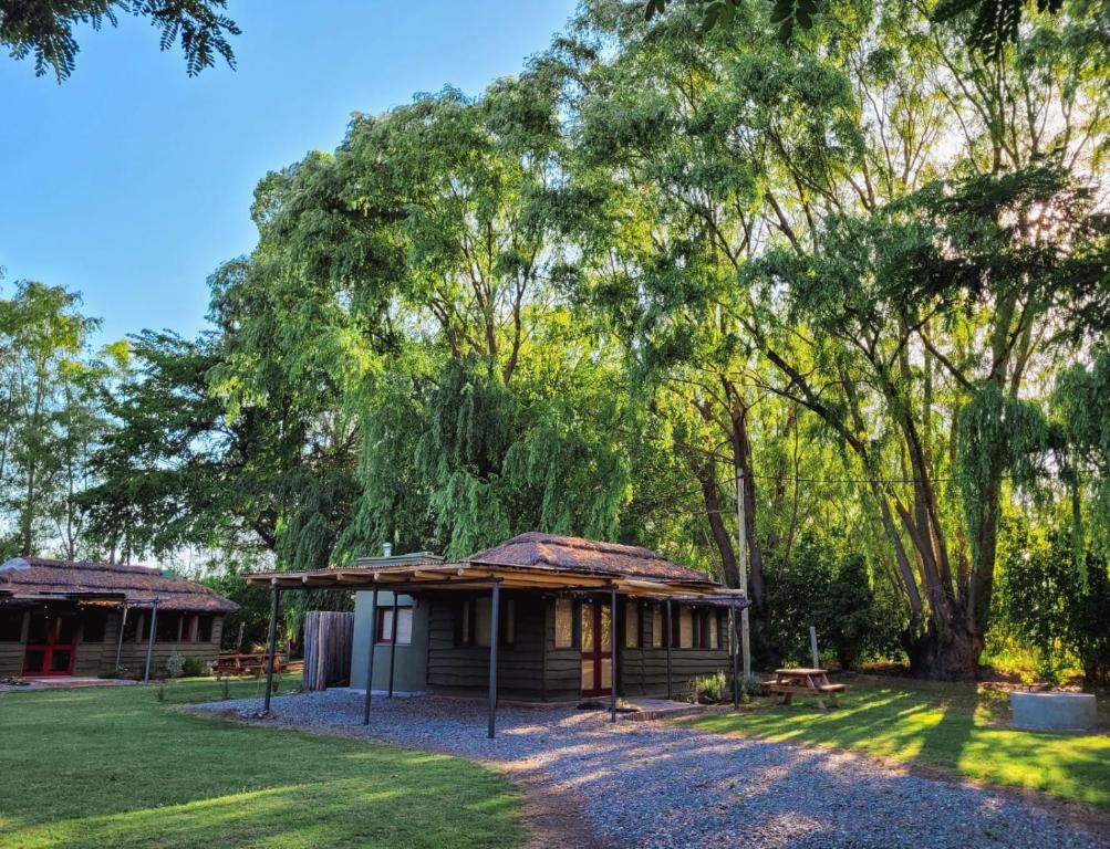 a small cabin in a park with trees at Finca La Saucina Casa de Campo in Tunuyán