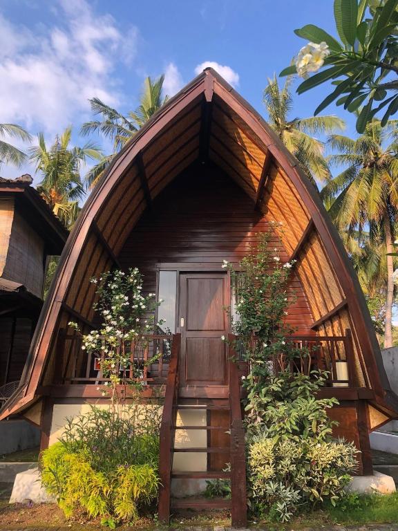 a small house with a curved roof and a door at Villa RR Senggigi in Senggigi