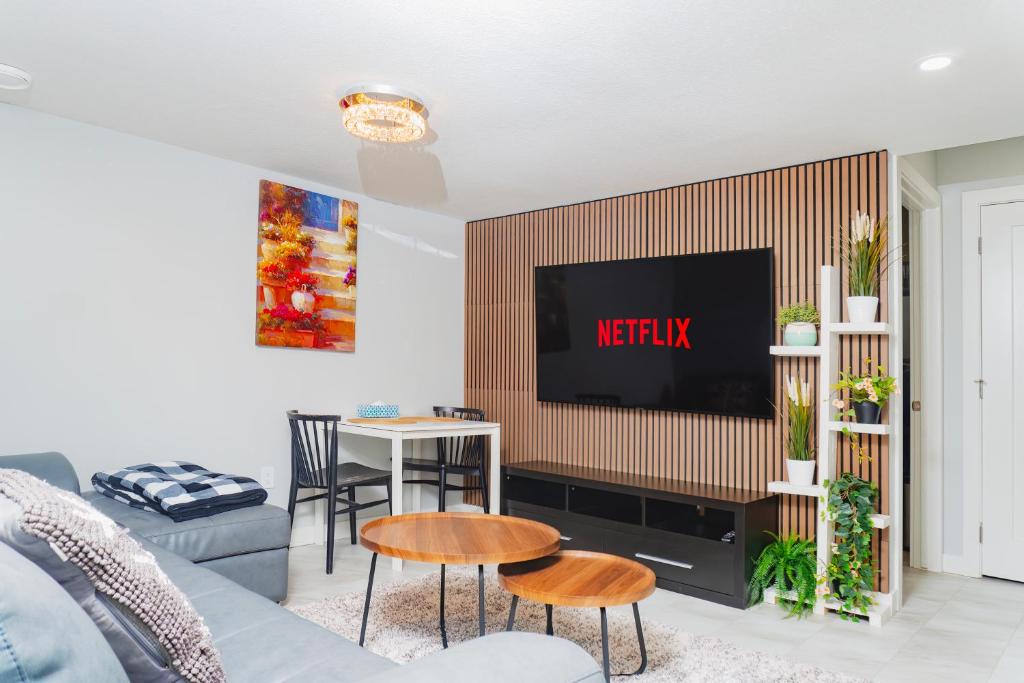 Una sala de estar con un televisor en la pared. en Entire Superior 2-bedroom private suite, en Edmonton