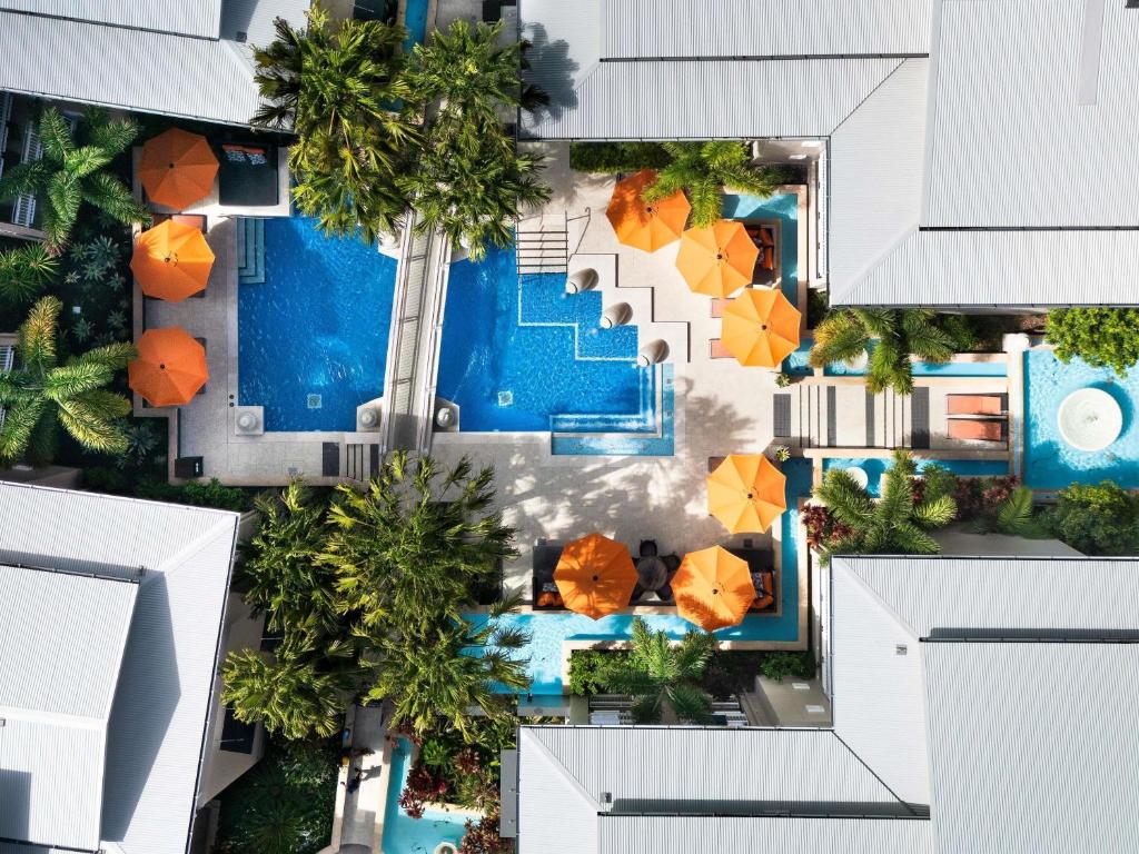 an aerial view of a resort pool with umbrellas at The Sebel Noosa in Noosa Heads