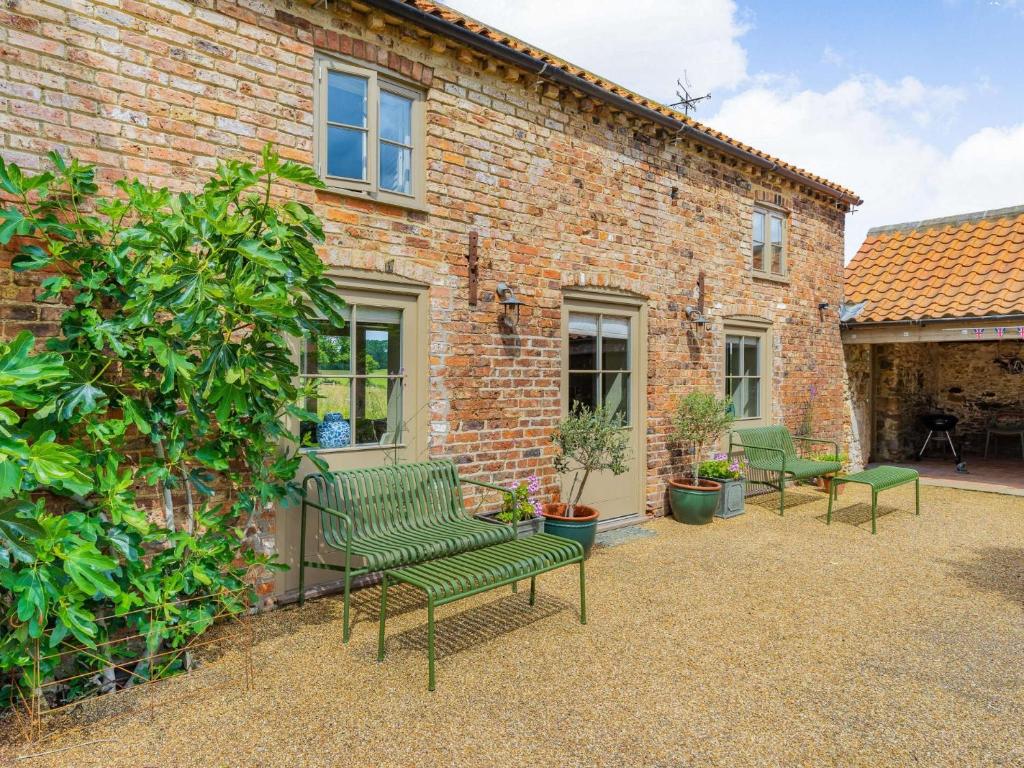 a group of green chairs in front of a brick building at 1 bed property in York G0057 in Marton in the Forest