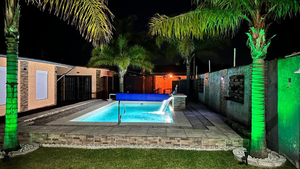 a swimming pool with a slide in a backyard at night at Monoambiente a pasos del mar, Moderno y completo in Parque del Plata