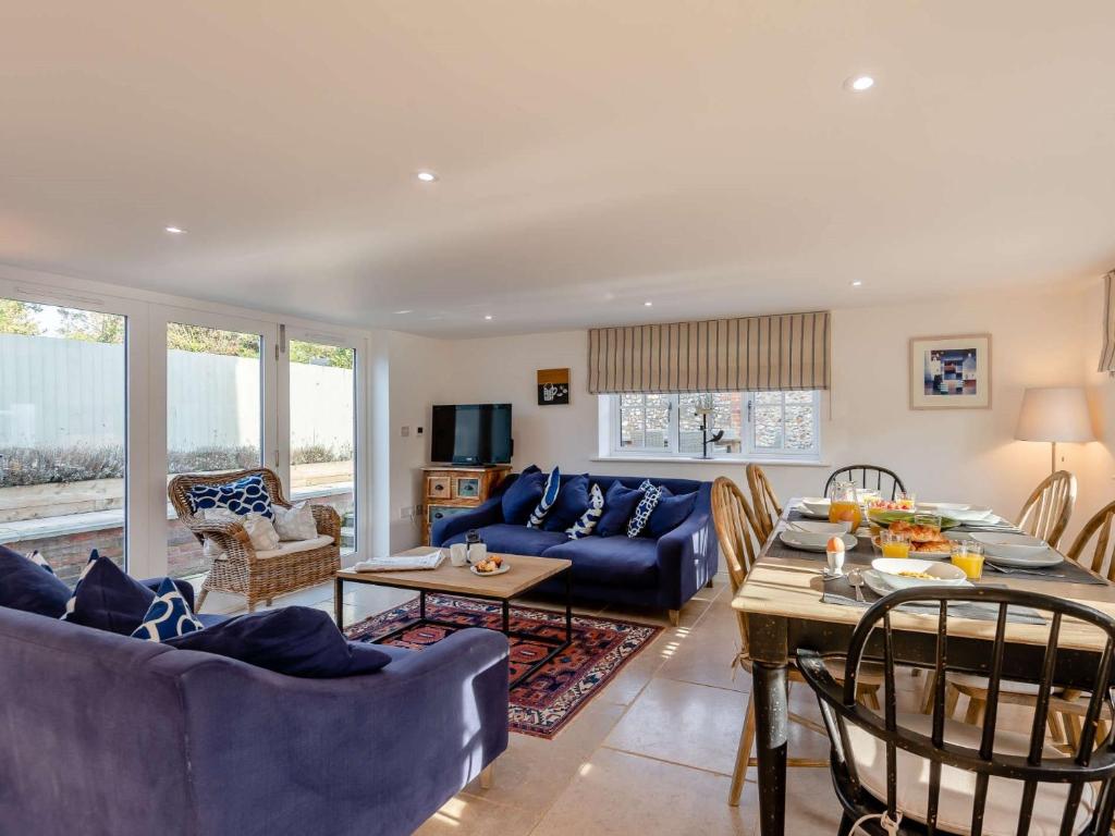a living room with a blue couch and a table at 3 Bed in Stiffkey 85636 in Stiffkey