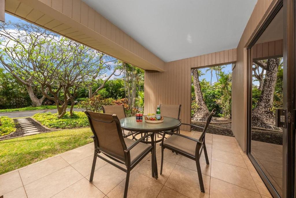 a dining room with a table and chairs on a patio at Kaanapali Alii 411 · ALII 411 Ground Floor 2BD at OceanFront Res in Lahaina