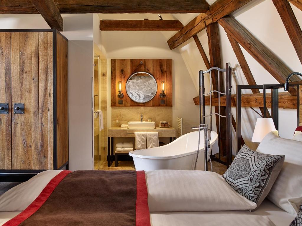 sypialnia z łóżkiem oraz łazienka z wanną w obiekcie PEST-BUDA Design Hotel w Budapeszcie