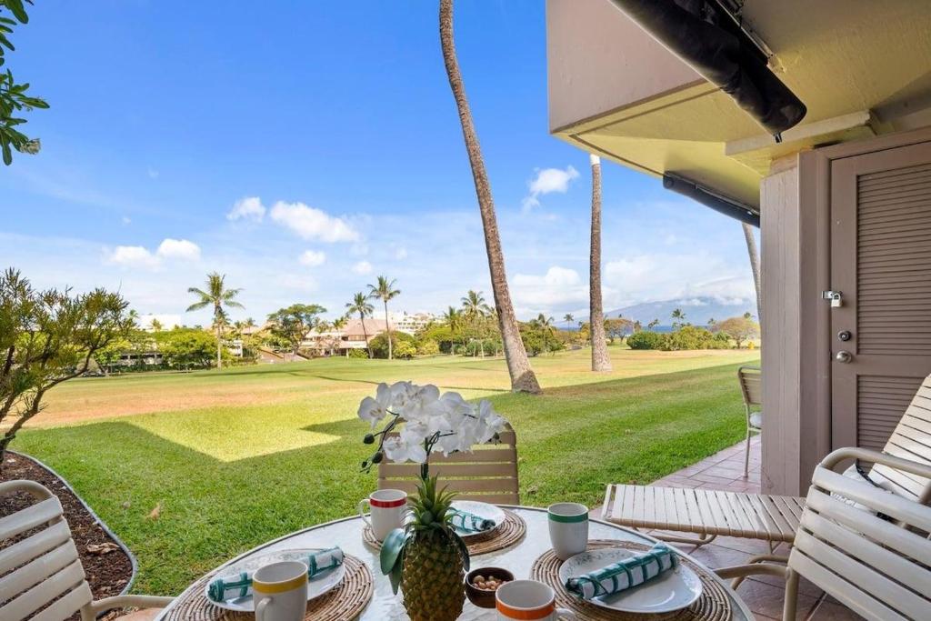 - une table sur une terrasse couverte avec vue sur un parcours de golf dans l'établissement Eldorado A107 · EL A107 Remodeled Studio, Golf Course, Beach!, à Kahana