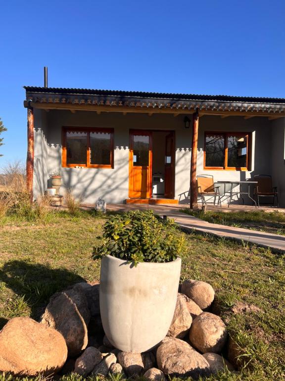 a small white house with a pot in front of it at Ranchos de la Tata in Las Calles