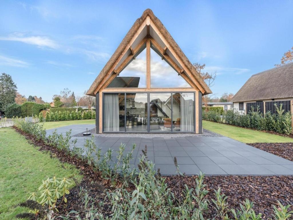 Casa con techo de paja y patio en Modern bungalow in Baarle-Nassau with pond view, en Schaluinen